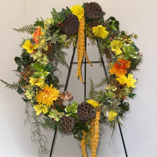 Large floral wreath with yellow and orange blooms on a stand