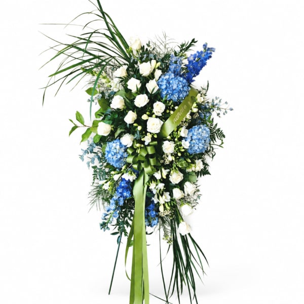 Tall blue and white floral spray with ribbon on a white background