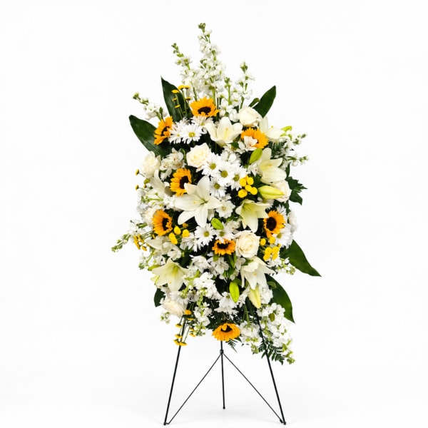 Tall floral standing spray with white lilies, daisies, and yellow sunflowers