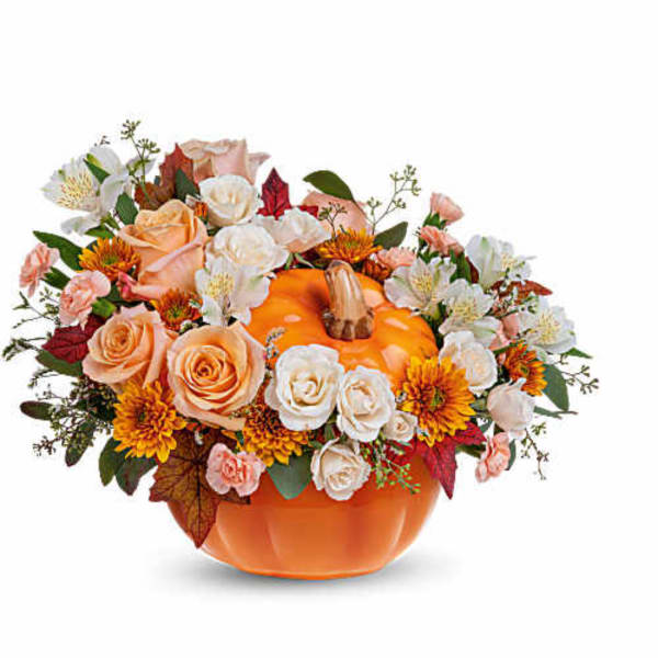 Pumpkin-shaped vase filled with roses and autumn flowers