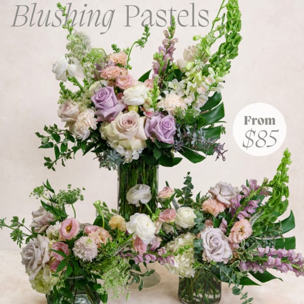 Pastel floral arrangement with roses, lisianthus, and snapdragons in a glass vase