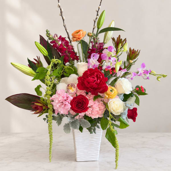 Colorful mixed flower arrangement in a white vase