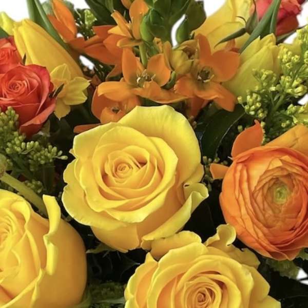 Bouquet of yellow, orange, and red roses with small orange flowers