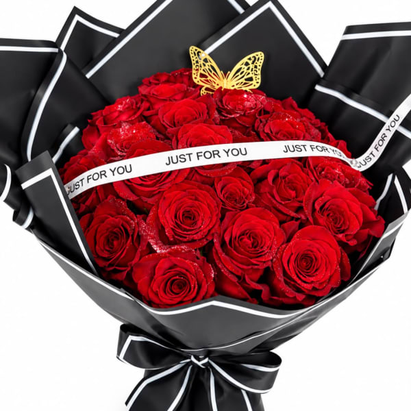 Bouquet of red roses wrapped in black paper with a white ribbon