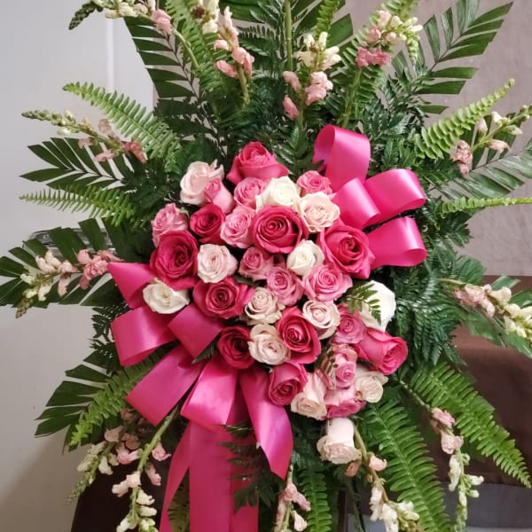 Pink and white rose bouquet with ferns and a bright pink ribbon
