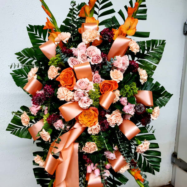 Large floral standing spray with pink and orange roses and carnations