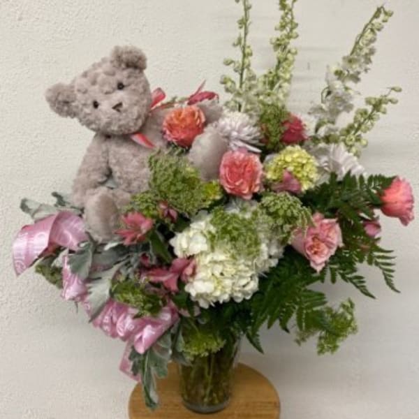 Bouquet with a teddy bear and pink flowers in a glass vase