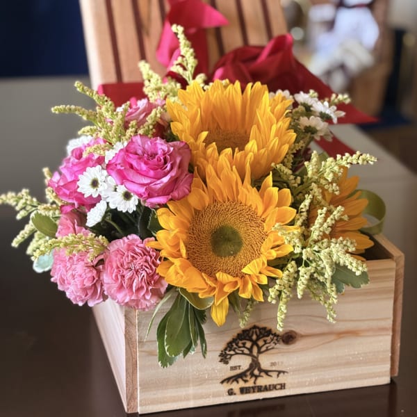 Sunflowers, pink roses, and white daisies in a wooden box