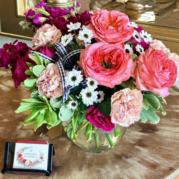 Mixed pink and white flowers arranged in a clear glass vase