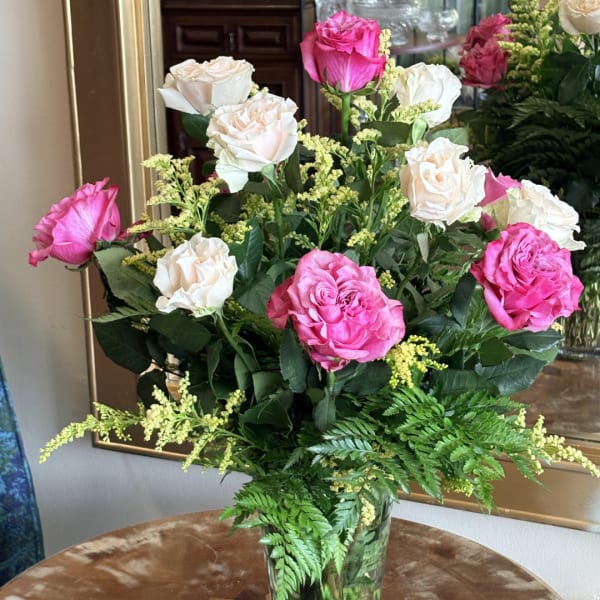Pink and white roses arranged in a clear glass vase