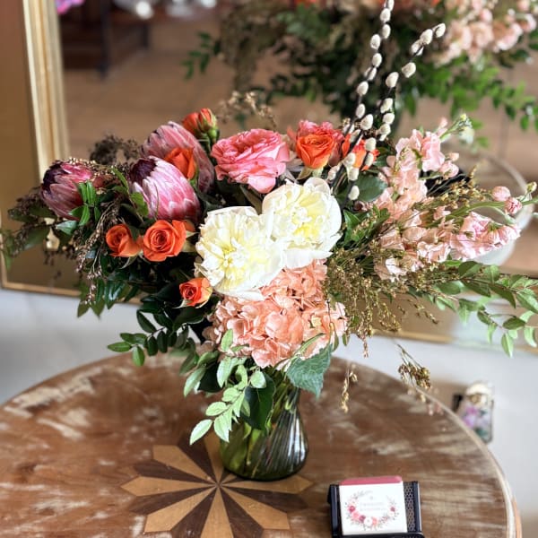 Mixed bouquet in a glass vase with pink, white, and orange blooms