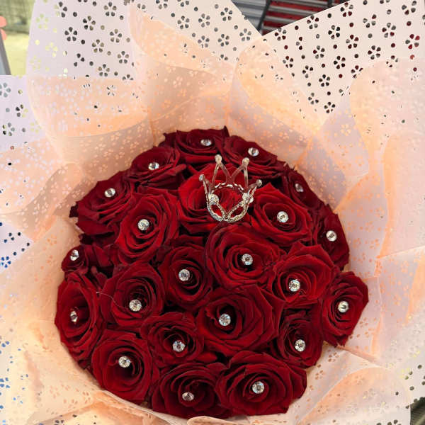 Bouquet of red roses wrapped in pale pink patterned paper