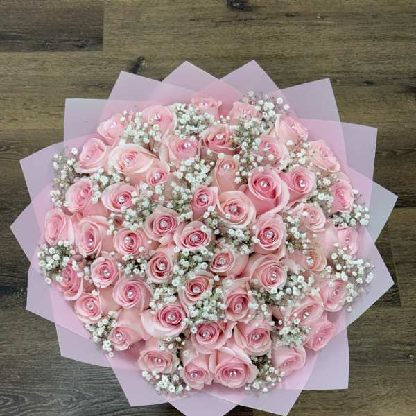 Pink rose bouquet with baby's breath wrapped in pink paper