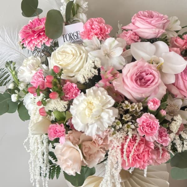 Pink and white mixed bouquet with roses, carnations, and orchids