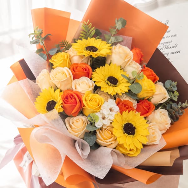 Bouquet of yellow sunflowers and orange roses wrapped in orange paper