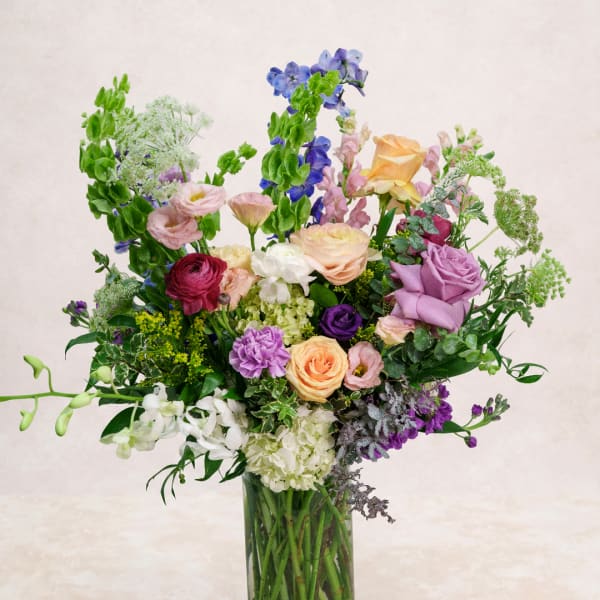 Mixed bouquet of colorful flowers in a clear glass vase