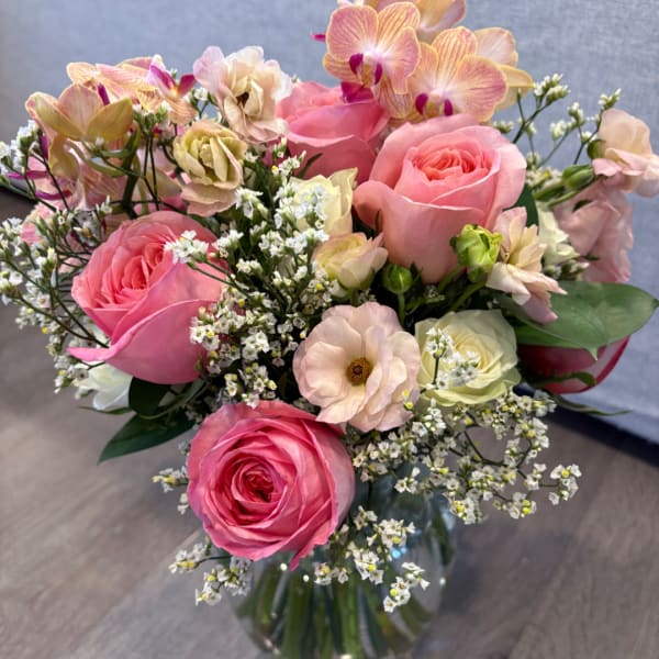 Pink roses and pale orchids in a glass vase
