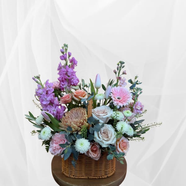Mixed pastel flower arrangement in a wicker basket