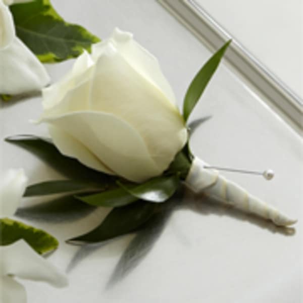 White rose boutonniere with wrapped stem and pearl pin on a white surface