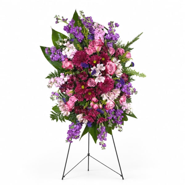 Standing floral spray with pink, purple, and white flowers on a metal easel