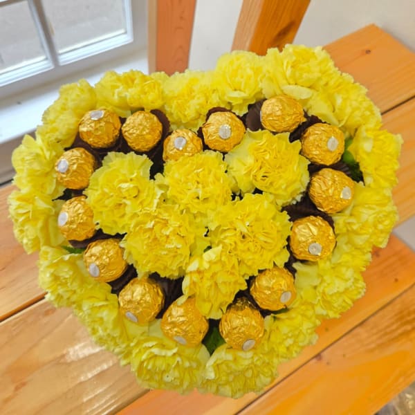 Yellow carnation bouquet with gold-wrapped chocolates