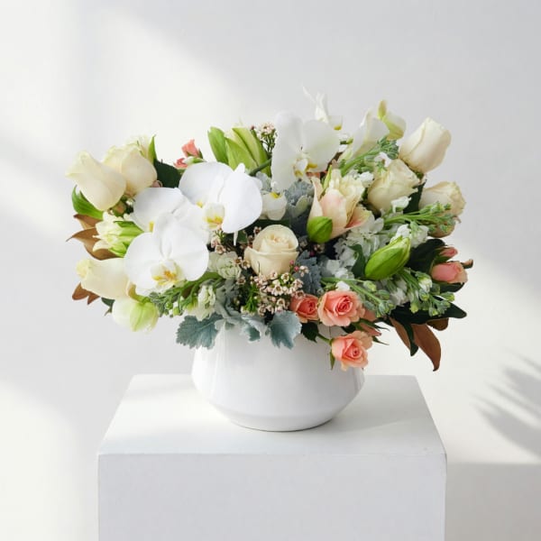 White orchid and rose arrangement in a white vase