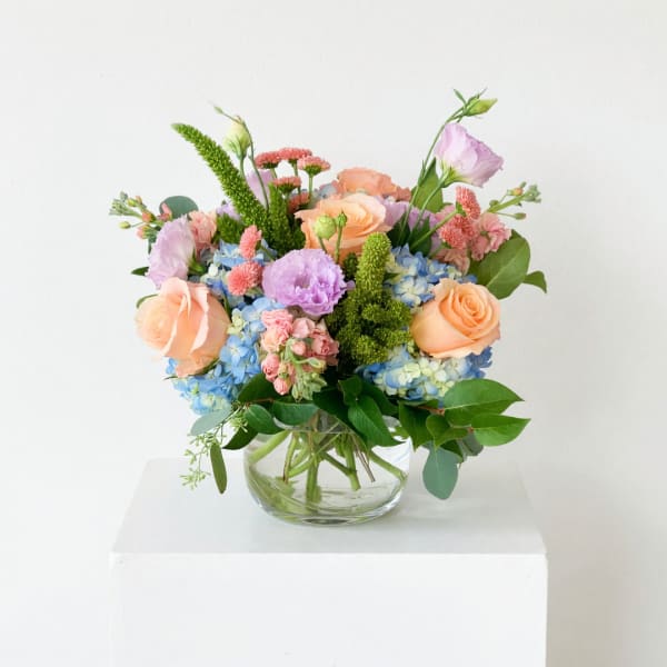 Pastel mixed flower arrangement in a clear glass vase