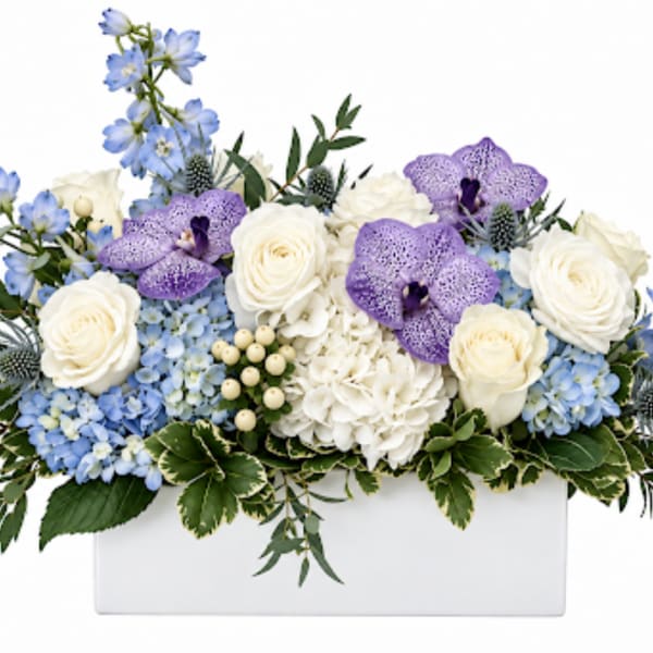 White and blue floral arrangement in a white box with purple orchids