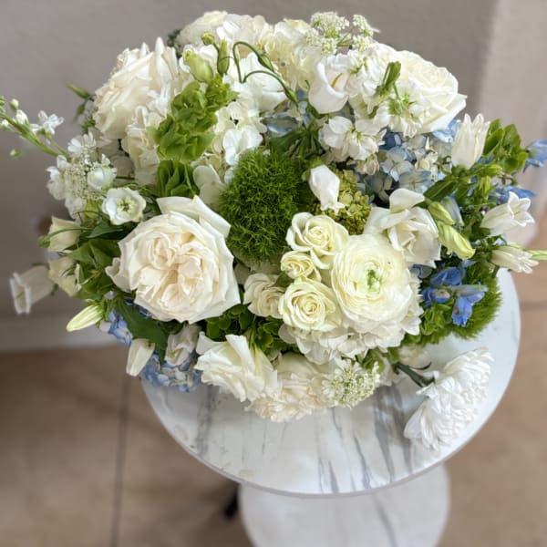White and blue mixed bouquet in a round white vase