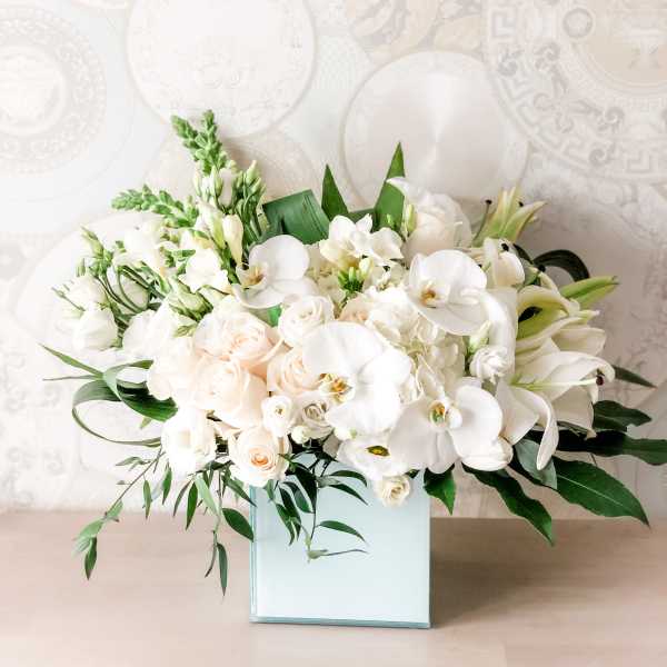 White floral arrangement in a square glass vase