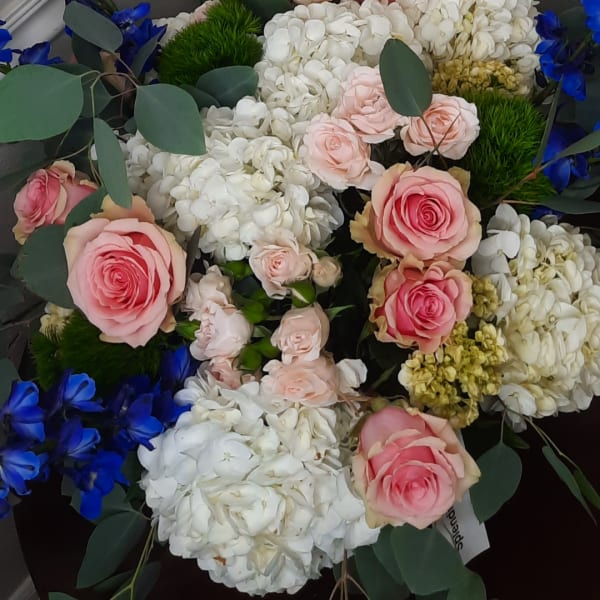 Pink roses with white hydrangeas and blue flowers in a bouquet