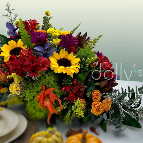 Colorful autumn floral arrangement with sunflowers and red blooms in a basket