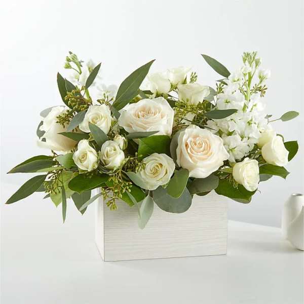 White roses and white blooms arranged in a white rectangular box