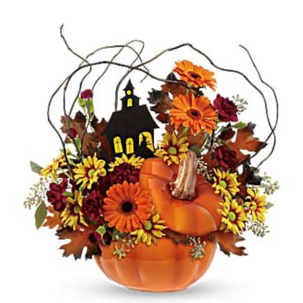 Pumpkin-shaped floral arrangement with orange and yellow flowers and a small house decoration