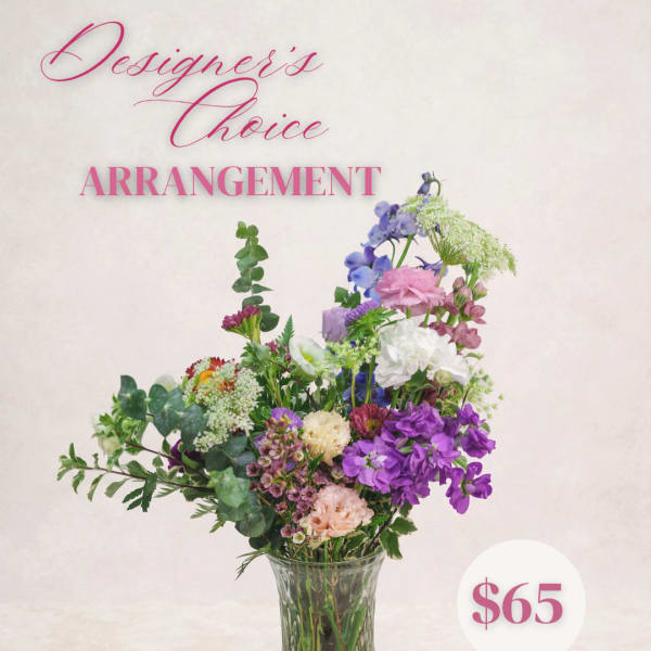 Mixed bouquet of purple, pink, and white flowers in a clear glass vase