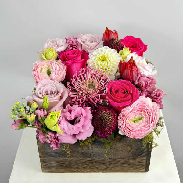 Pink and white mixed flower arrangement in a wooden box