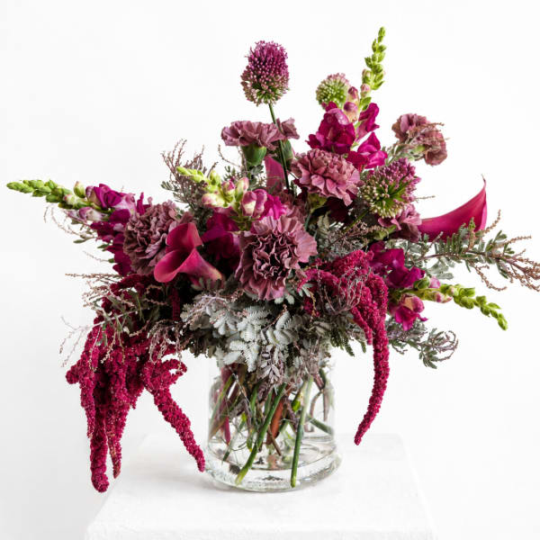 Magenta and mauve floral arrangement in a clear glass vase