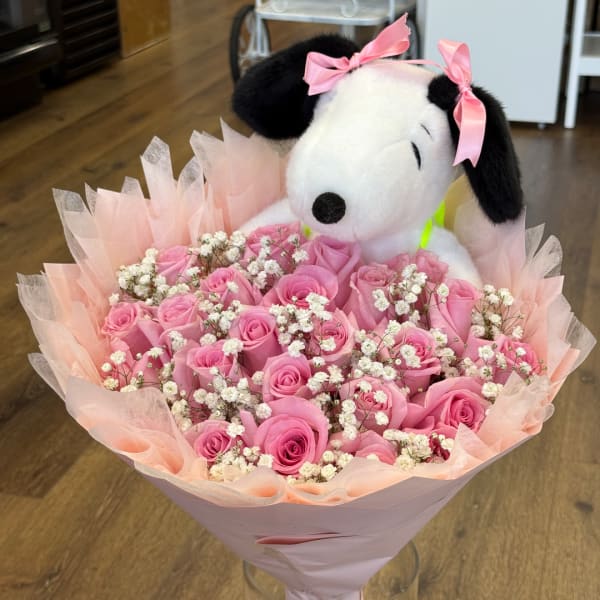 Pink rose bouquet with baby’s breath and a Snoopy plush topper