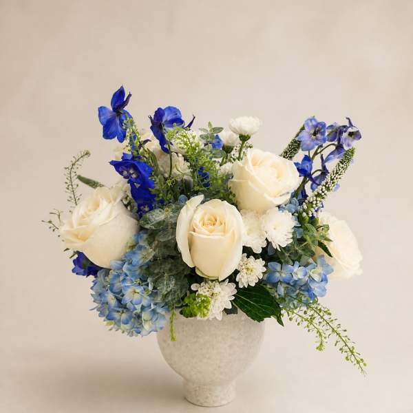 Blue and white floral arrangement in a white vase
