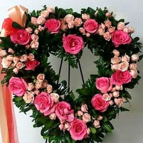 Heart-shaped floral wreath with pink roses and small pale pink blooms