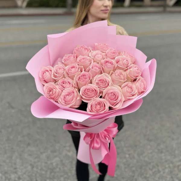 Bouquet of pink roses wrapped in pink paper with a ribbon