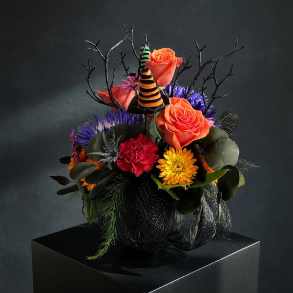 Halloween bouquet with orange roses, purple flowers, and striped witch hats