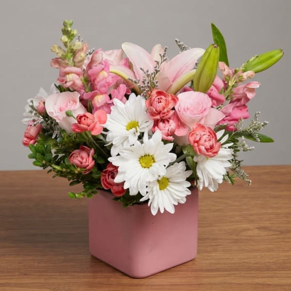 Pink and white mixed bouquet in a pink square vase