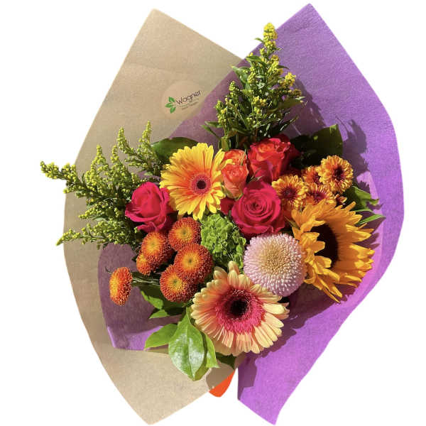 Bright mixed bouquet with gerbera daisies, roses, and chrysanthemums in purple wrap