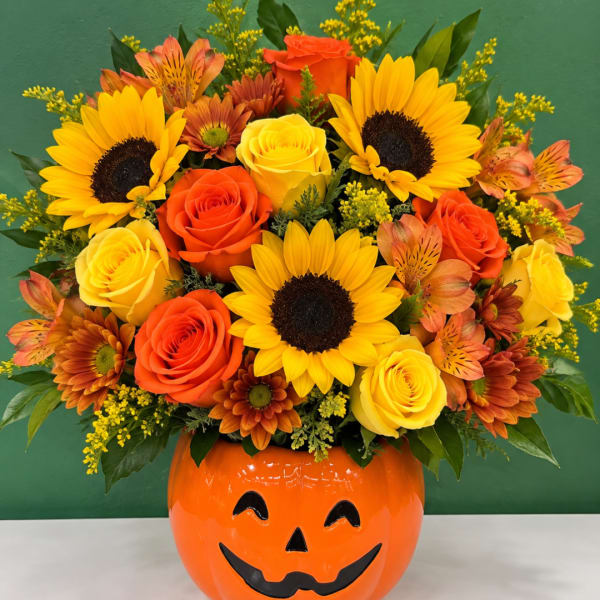Sunflower and rose arrangement in a jack-o'-lantern vase
