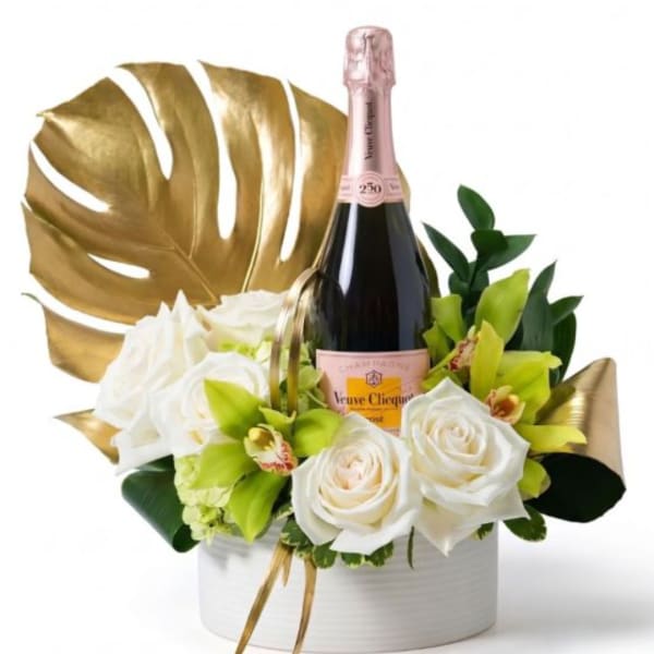 White roses and green orchids arranged with a champagne bottle in a white box