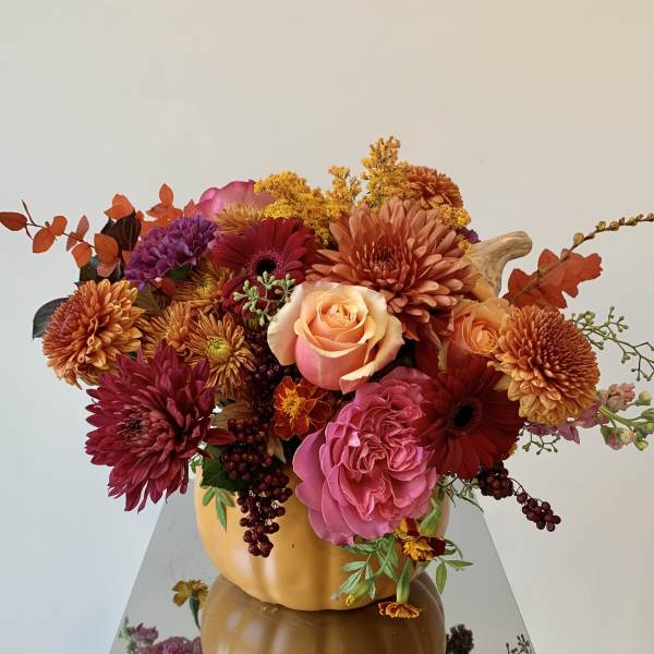 Autumn bouquet of mixed flowers in a pumpkin vase