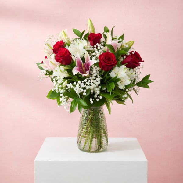 Red roses and white lilies in a clear glass vase