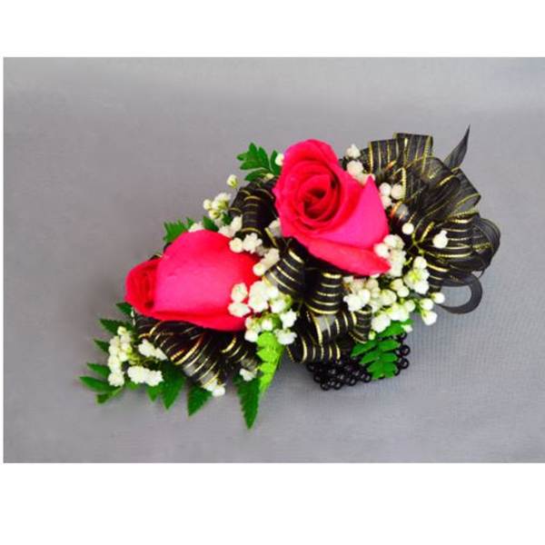 Two pink rose corsages with black ribbon and white filler flowers