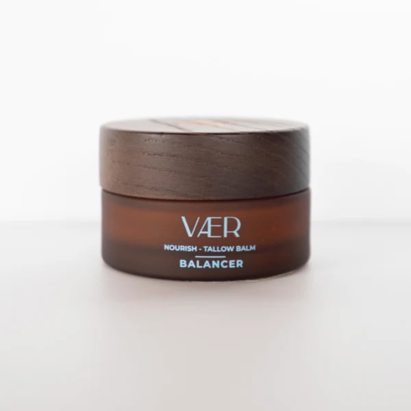 Brown cosmetic balm jar with a wooden lid on a white background